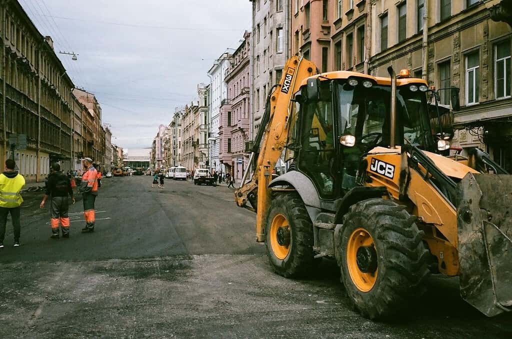 People and construction truck on a street between buildings